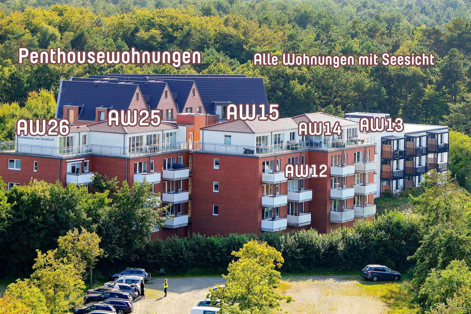 Wohnungen mit Seesicht in Waldnähe, mehrere Gebäude mit Balkonen und Parkplatz.