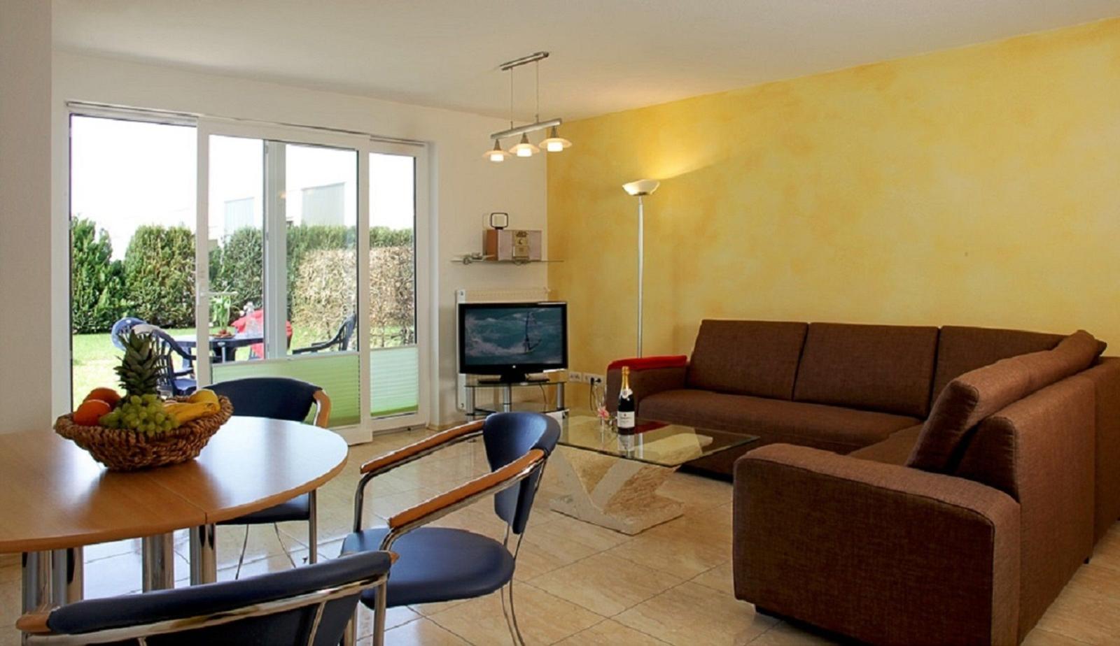 Wohnzimmer mit Sofa, Esstisch und Terrasse