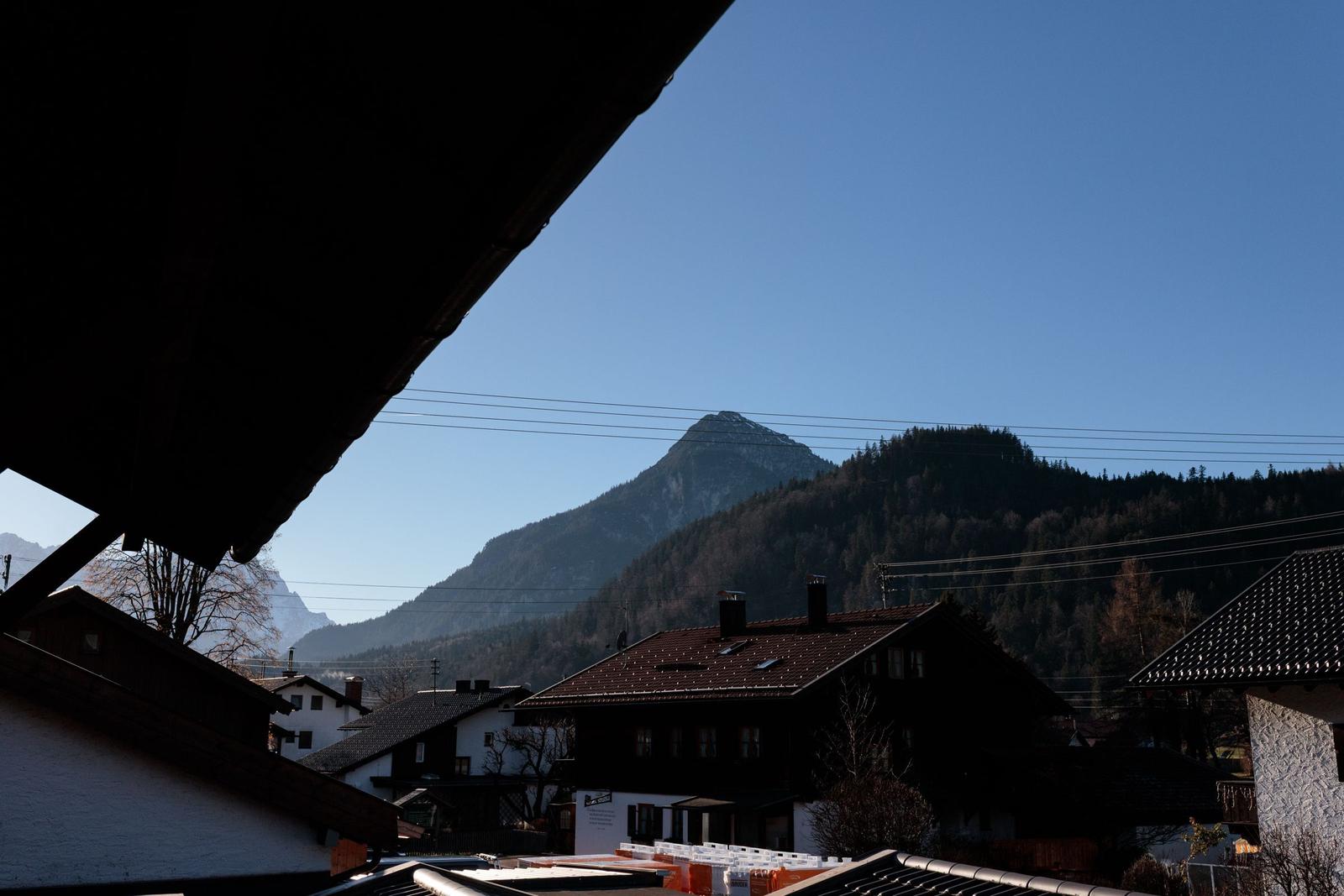 Panoramablick auf Berge und Häuser aus dem Dachbodenfenster.