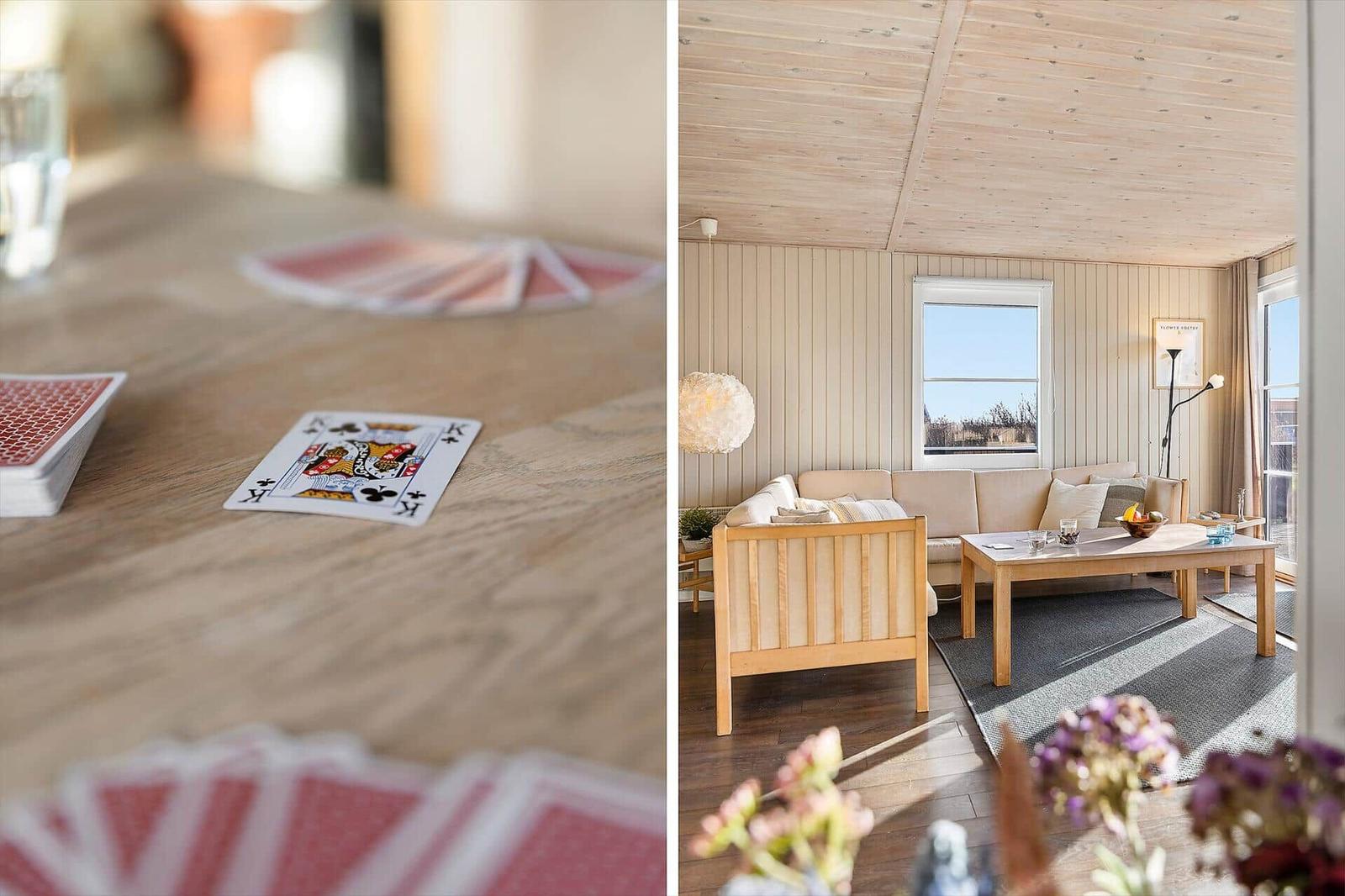 Ein Wohnzimmer mit Sofa, Tisch und Fenster. Auf dem Tisch liegen Spielkarten.