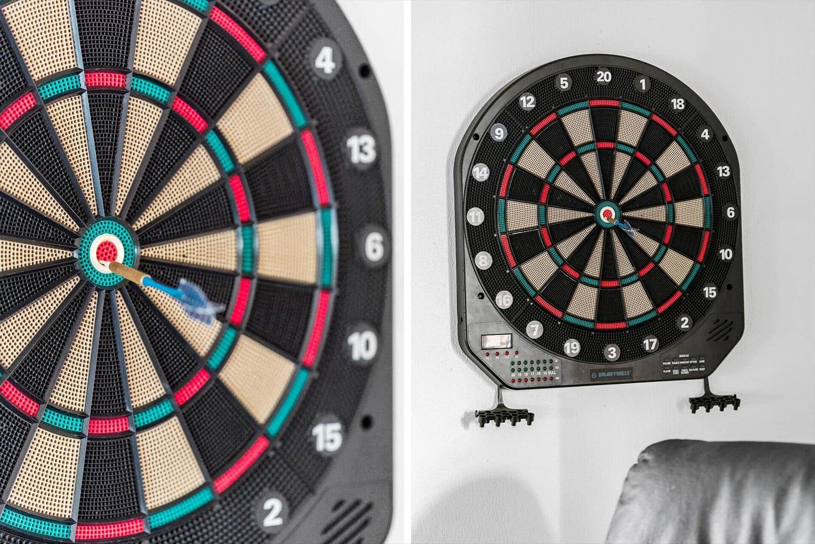 Electronic dartboard mounted on wall, one dart in the bullseye.
