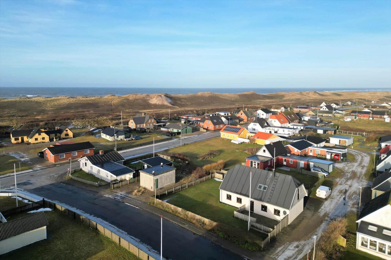 Village with houses and beach in the background.