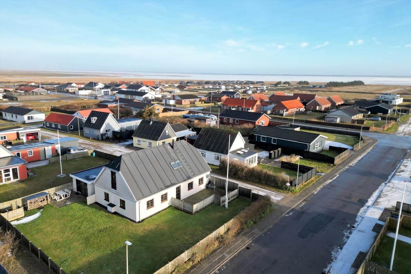 House with garden and view of coastal landscape with other houses.