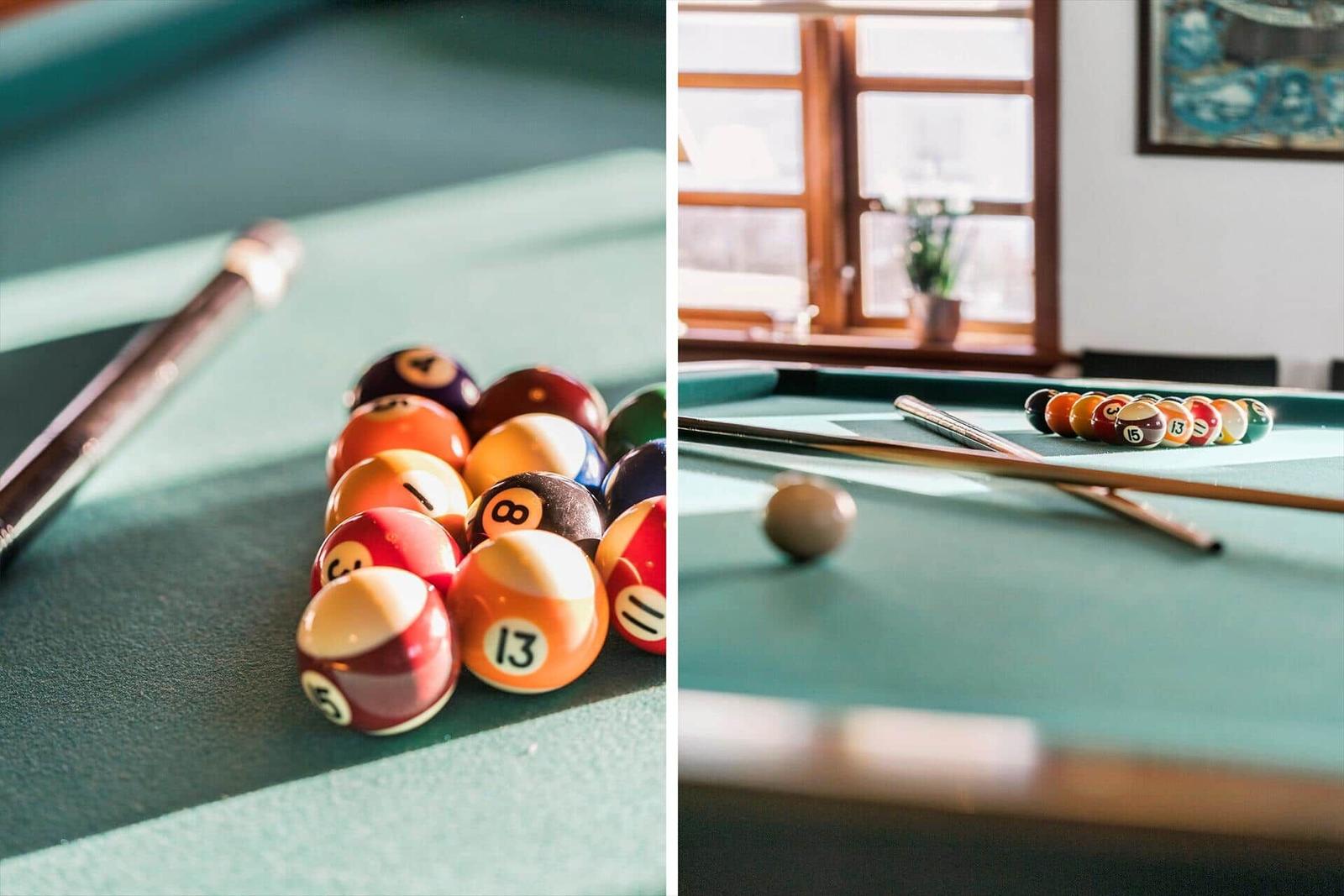 Billiard table with colored balls and cue. Window and plant in background.