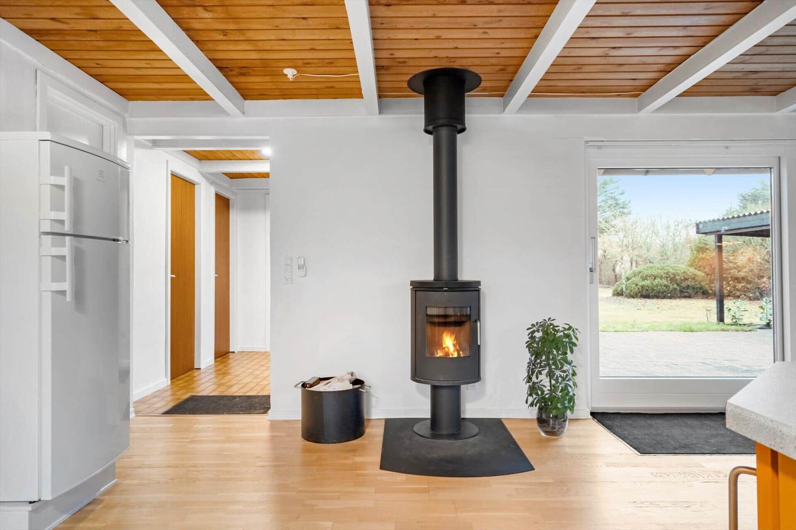 Küche mit Holzboden, Kaminofen und Blick auf den Garten.