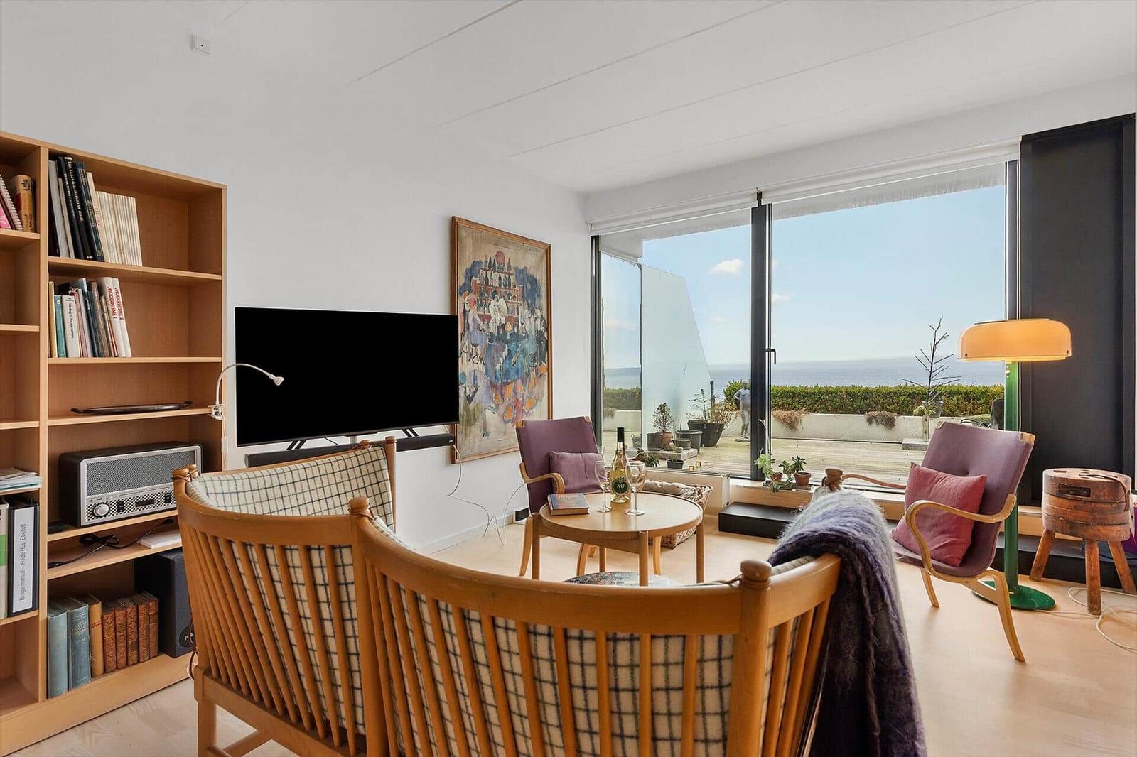Living room with sea view, wooden furniture and TV.