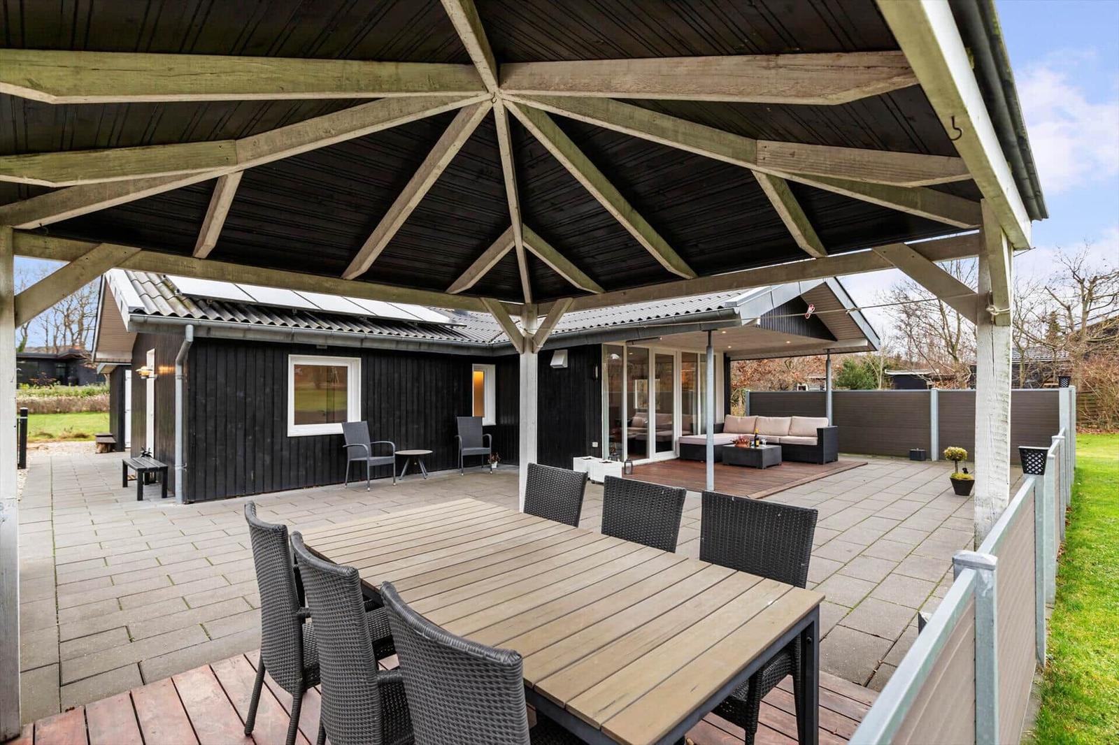 Terrace with seating group and dining table under roof