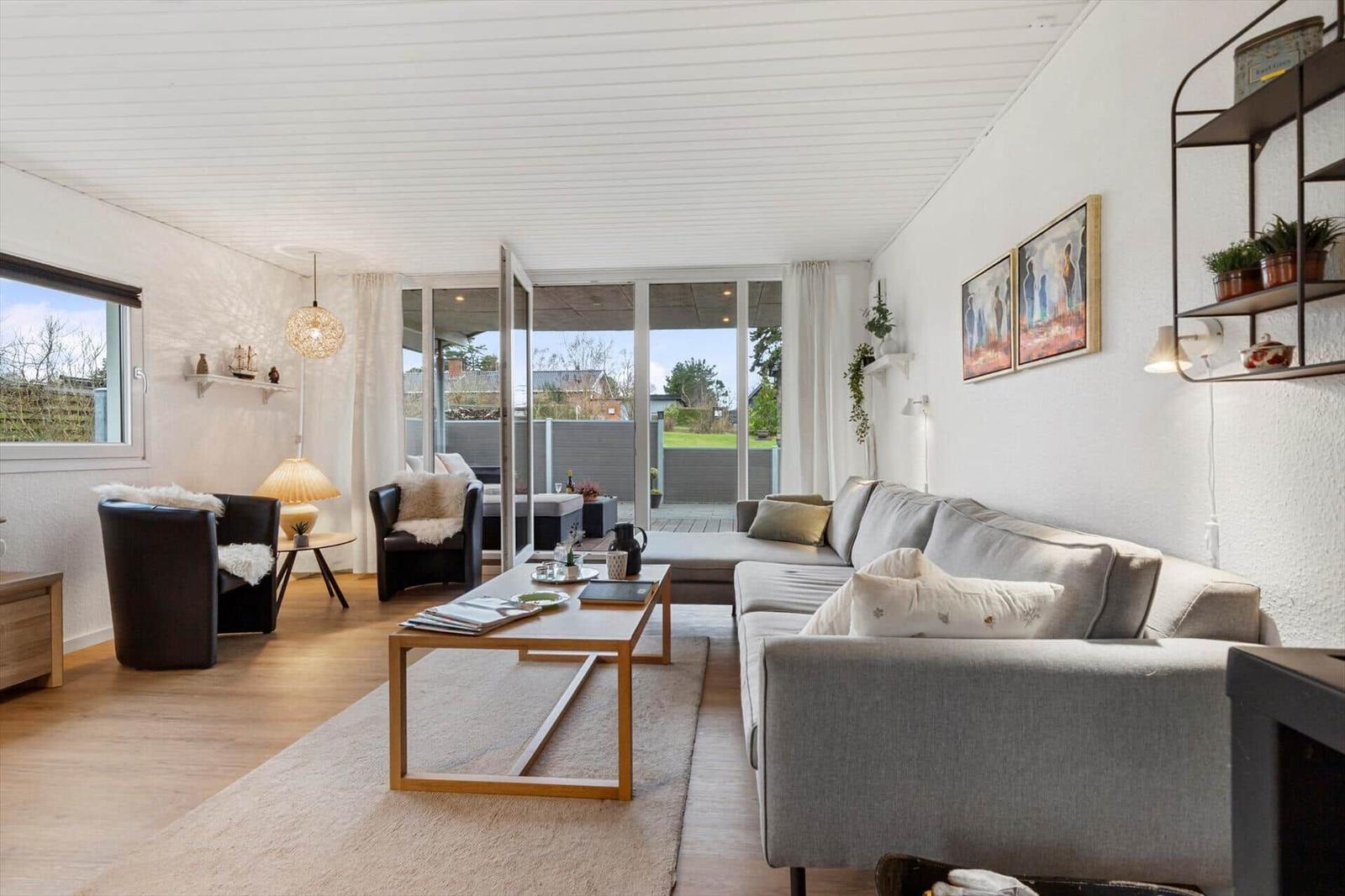 Living room with sofa, coffee table, and view of terrace