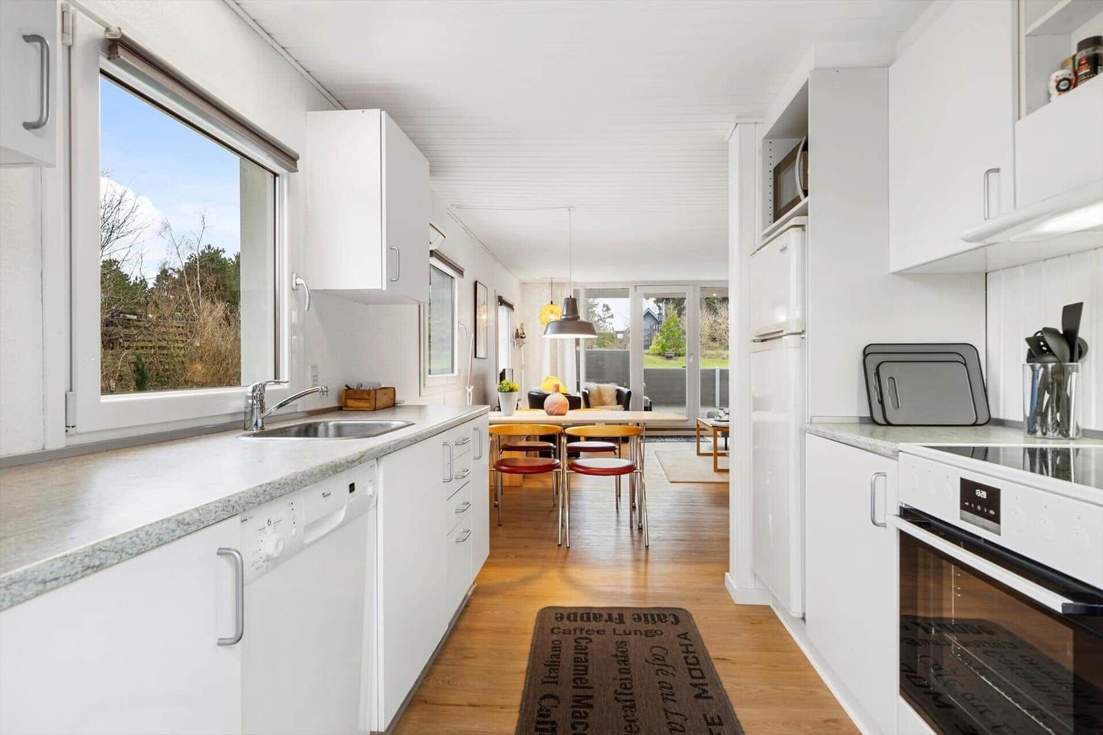 Kitchen with view to garden, dining area with table and chairs.
