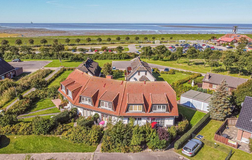 Haus mit rotem Dach, Garten und Blick auf Strand und Meer.