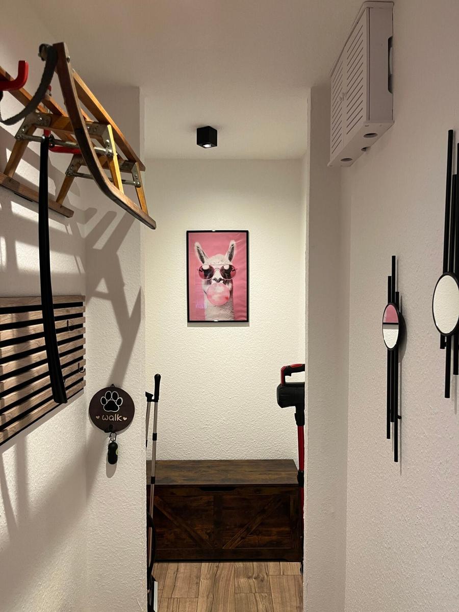 Eingangsbereich mit Wandbild, Holzbank und Aufbewahrungsmöbeln.