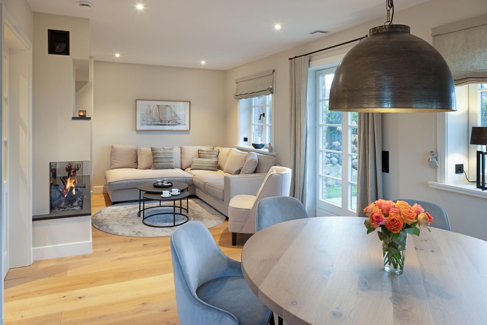 Wohn- und Essbereich mit Sofa, Esstisch und Kamin.