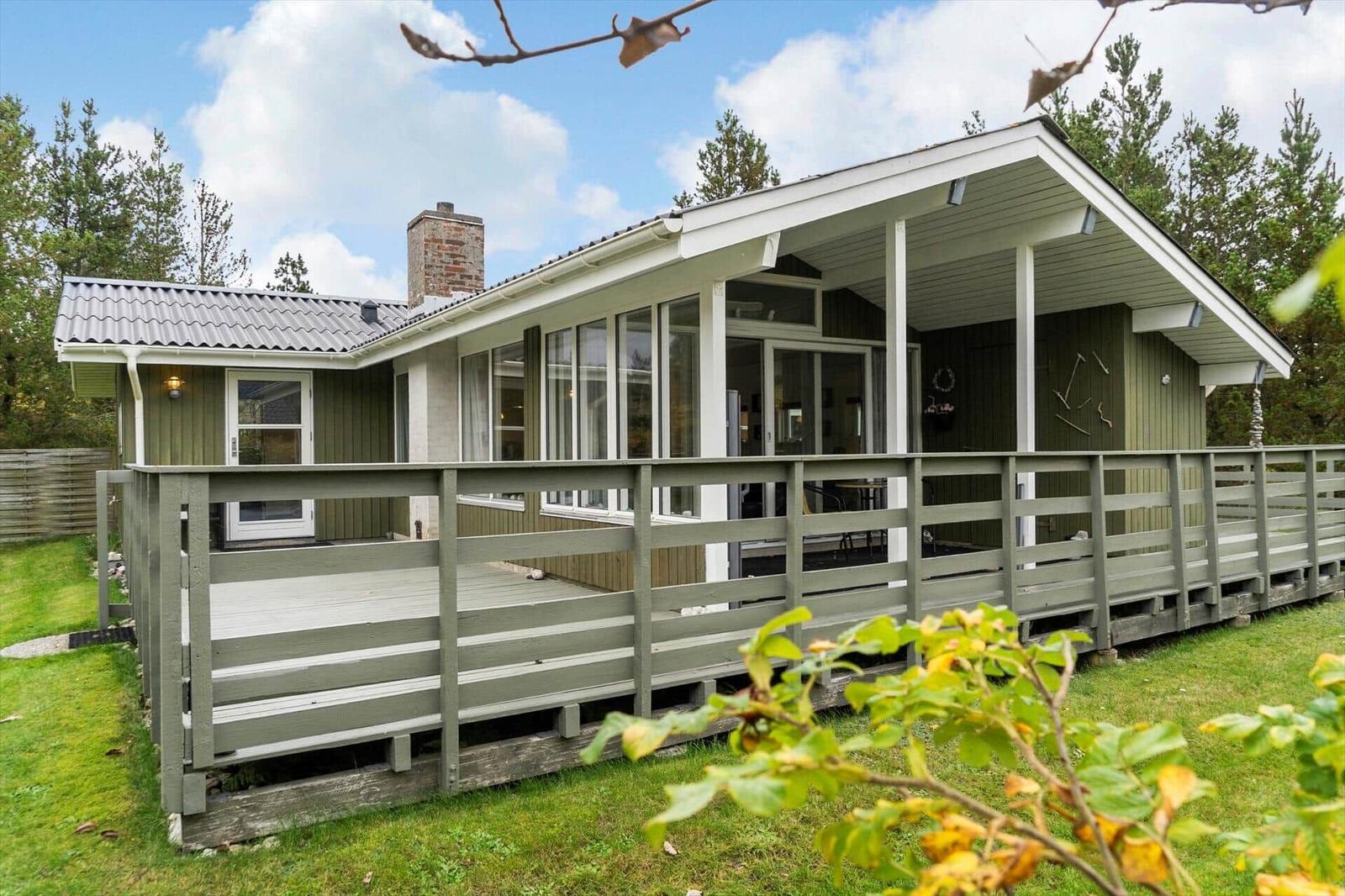 A house with a terrace and wooden veranda in the green.