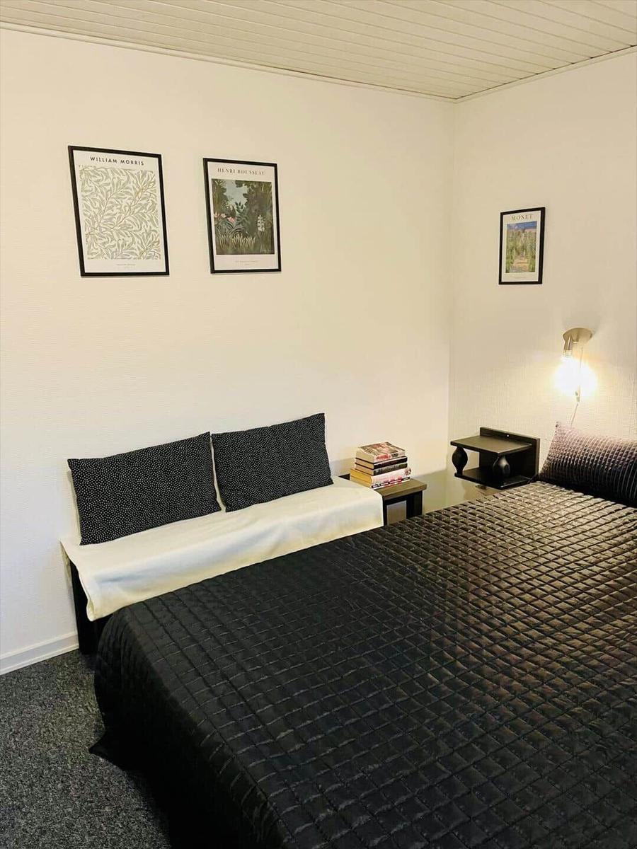 Bedroom with bed, wall art, and nightstand