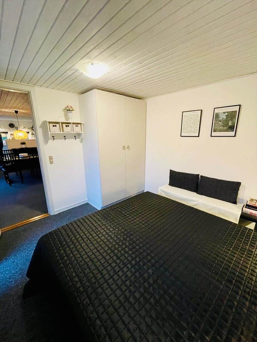 Bedroom with bed, wardrobe, and pictures on the wall.