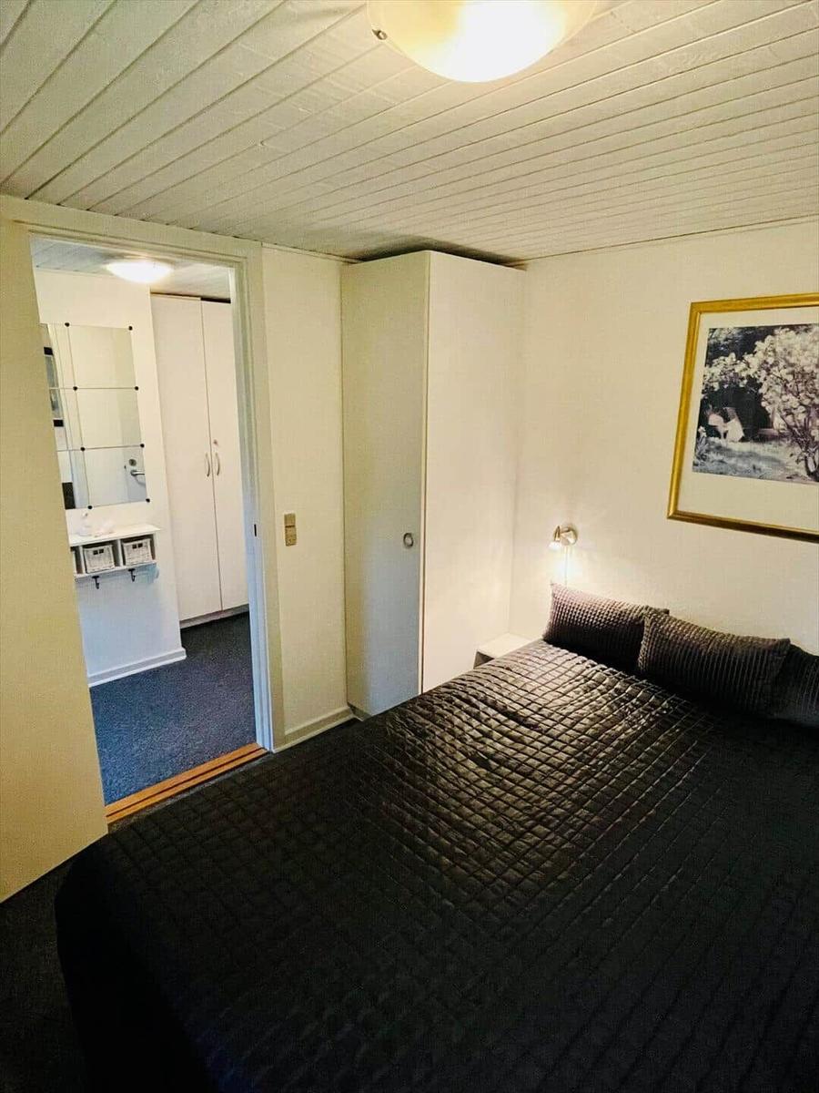 Bedroom with bed, wardrobe, and adjacent bathroom.