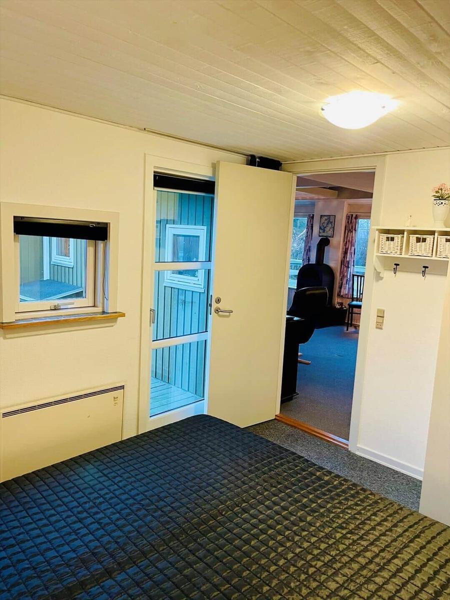 Bedroom with door to living area and small window.