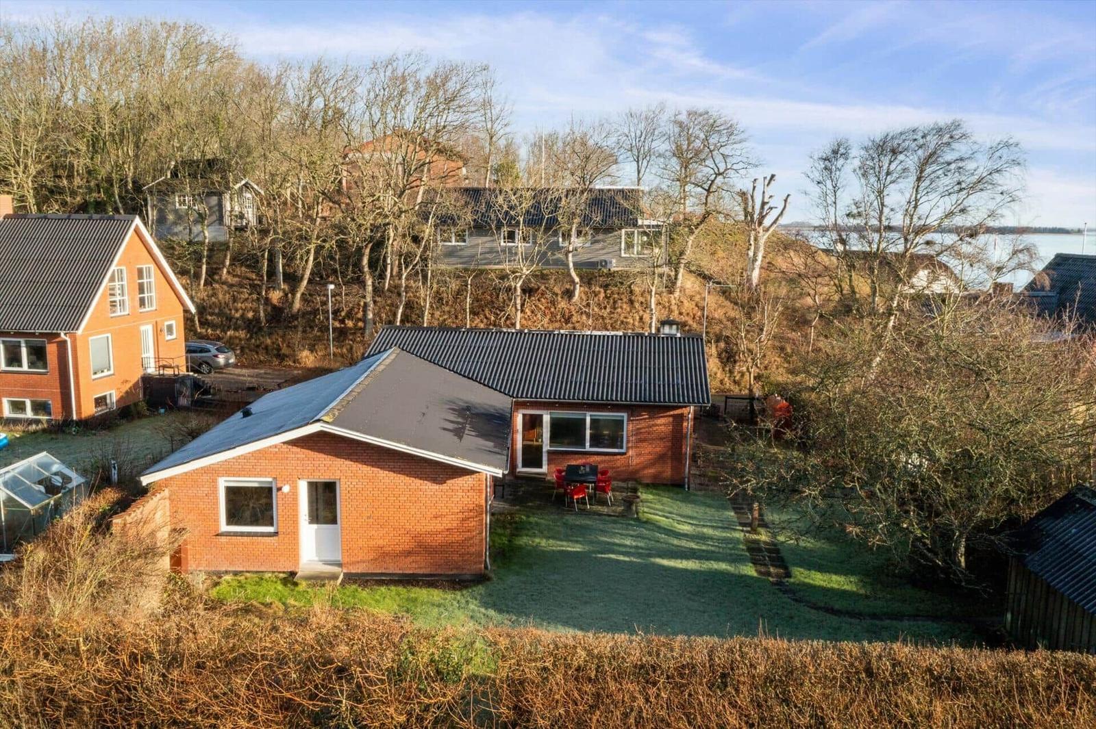 Red brick house with garden and view of water.