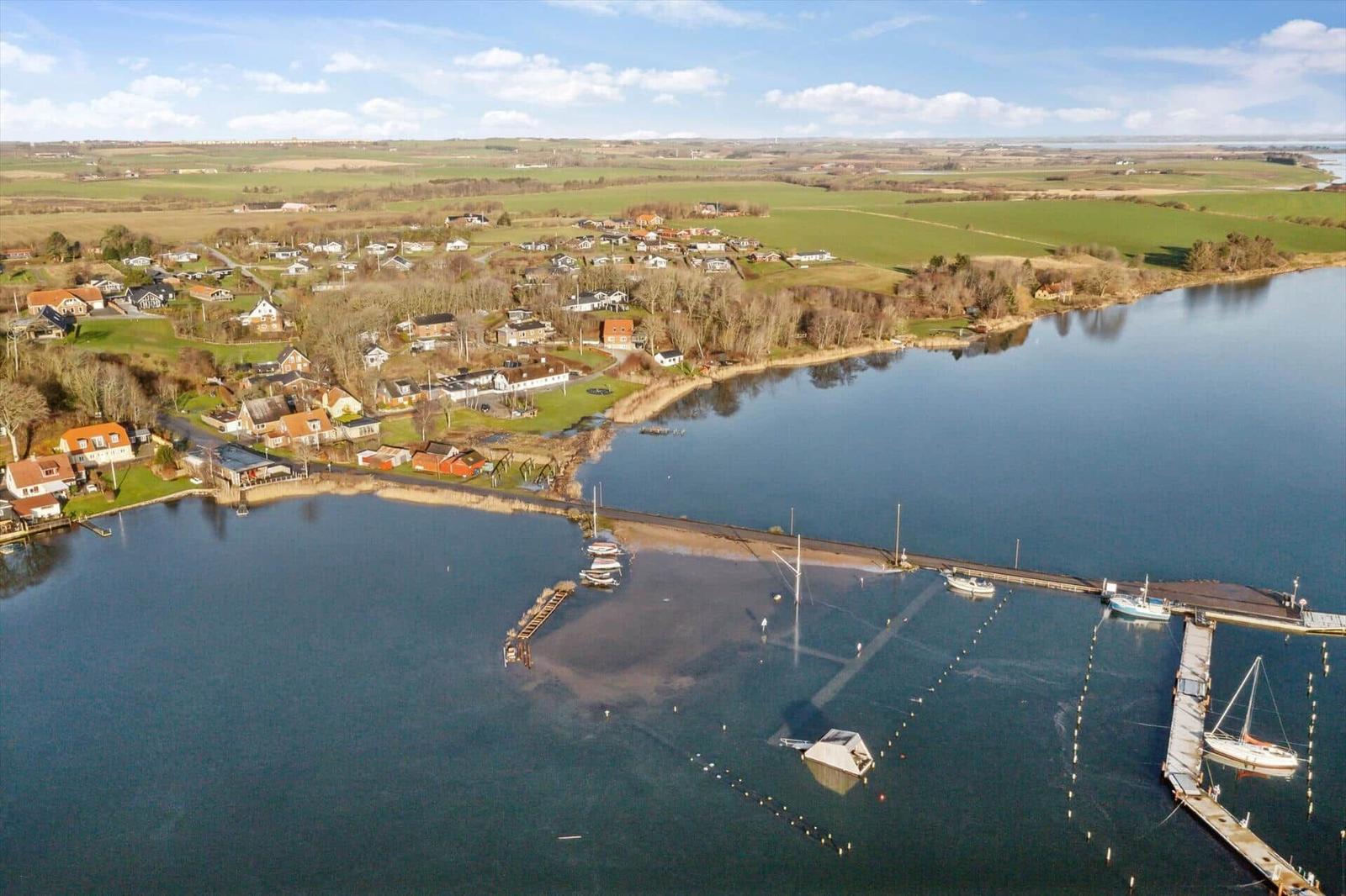 Aerial view of a harbor with boats and surrounding houses by a lake.