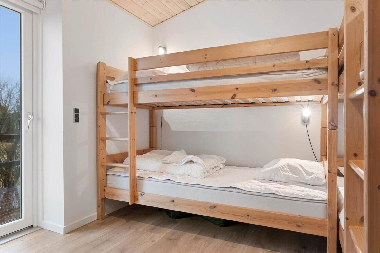 Room with wooden bed, window and wooden floor