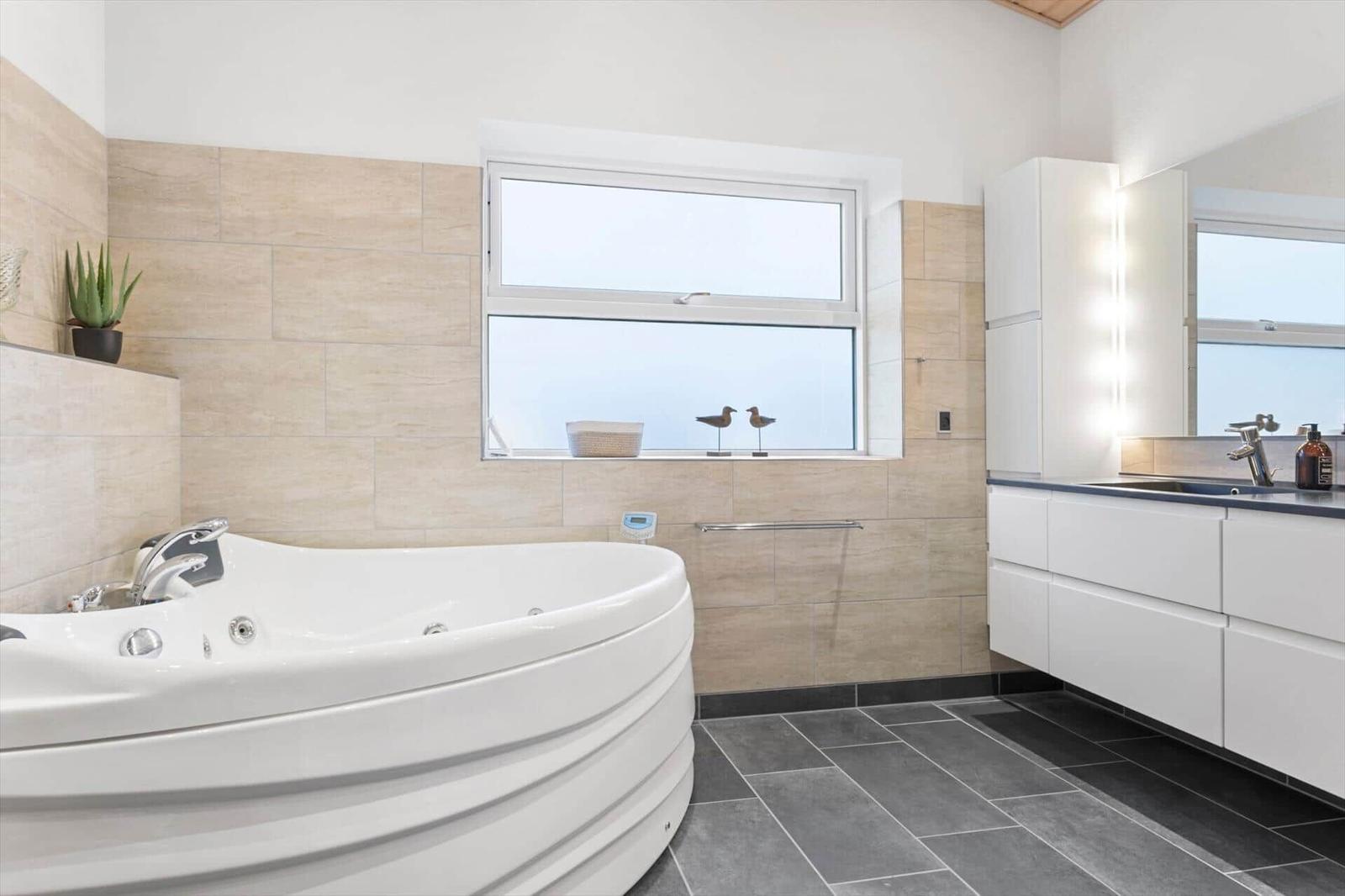 Bath with whirlpool, window, and sink with mirror