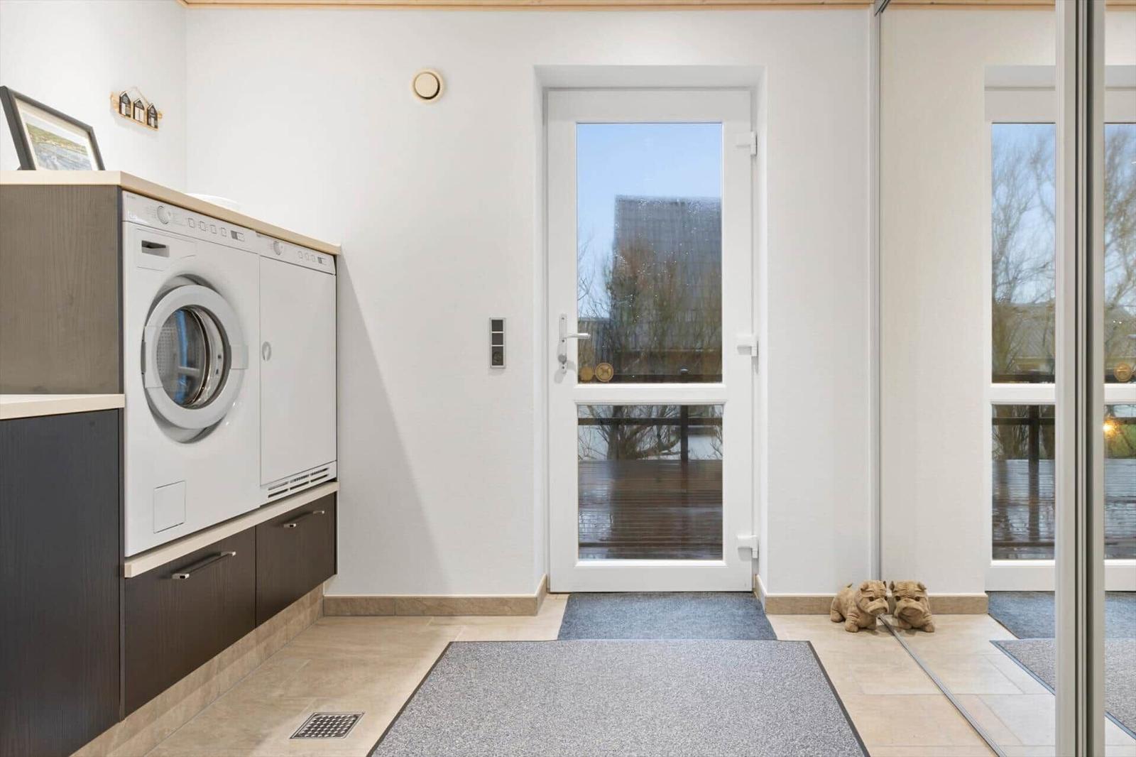 Entrance area with washing machine, door, and floor covering