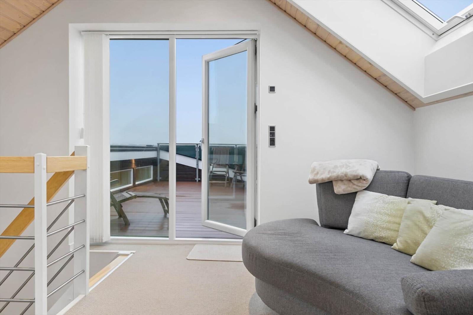 A living area with a view of a terrace with loungers.