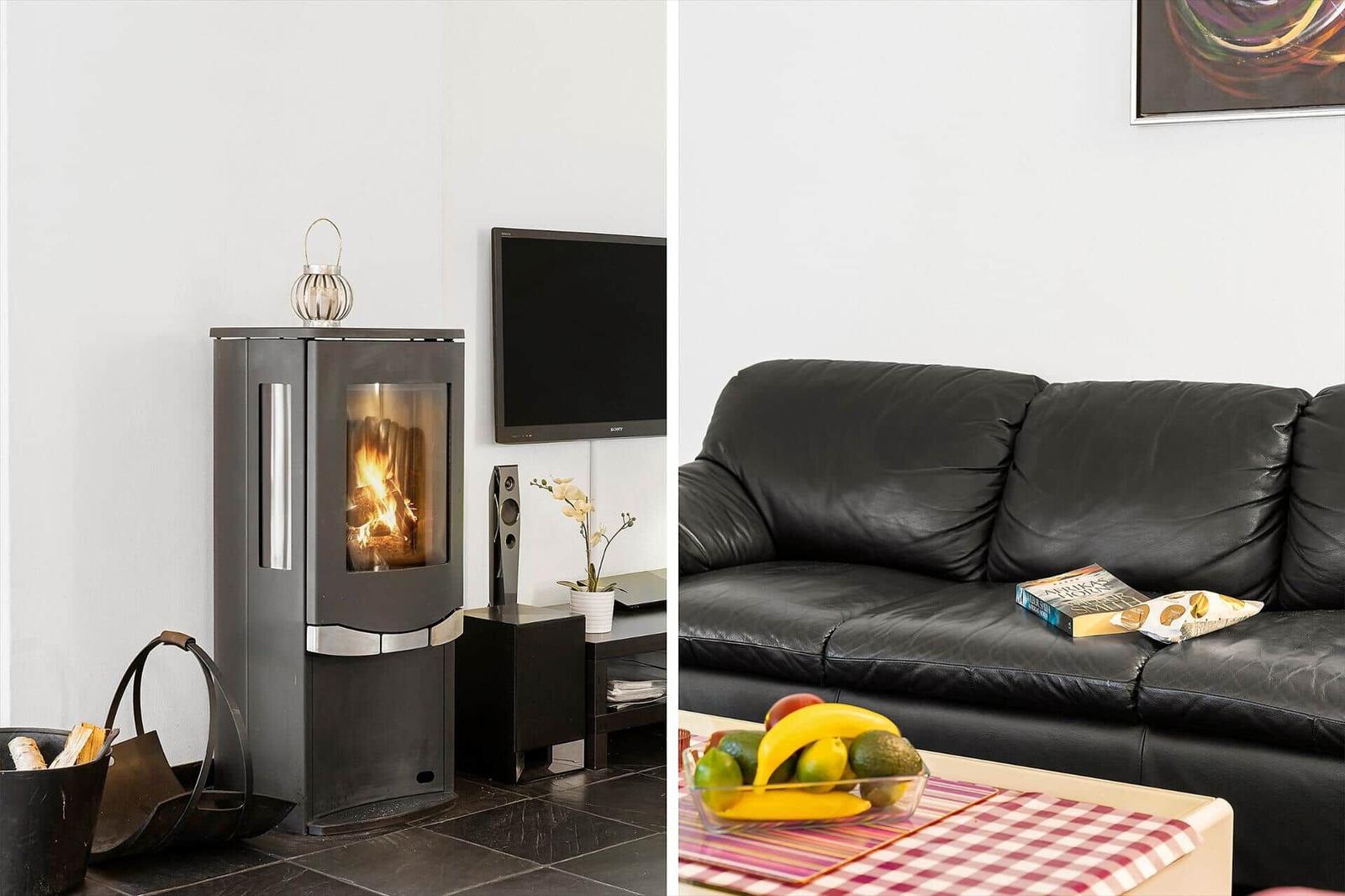 Living room with fireplace, sofa, and TV. Fruit and a book are on the table.