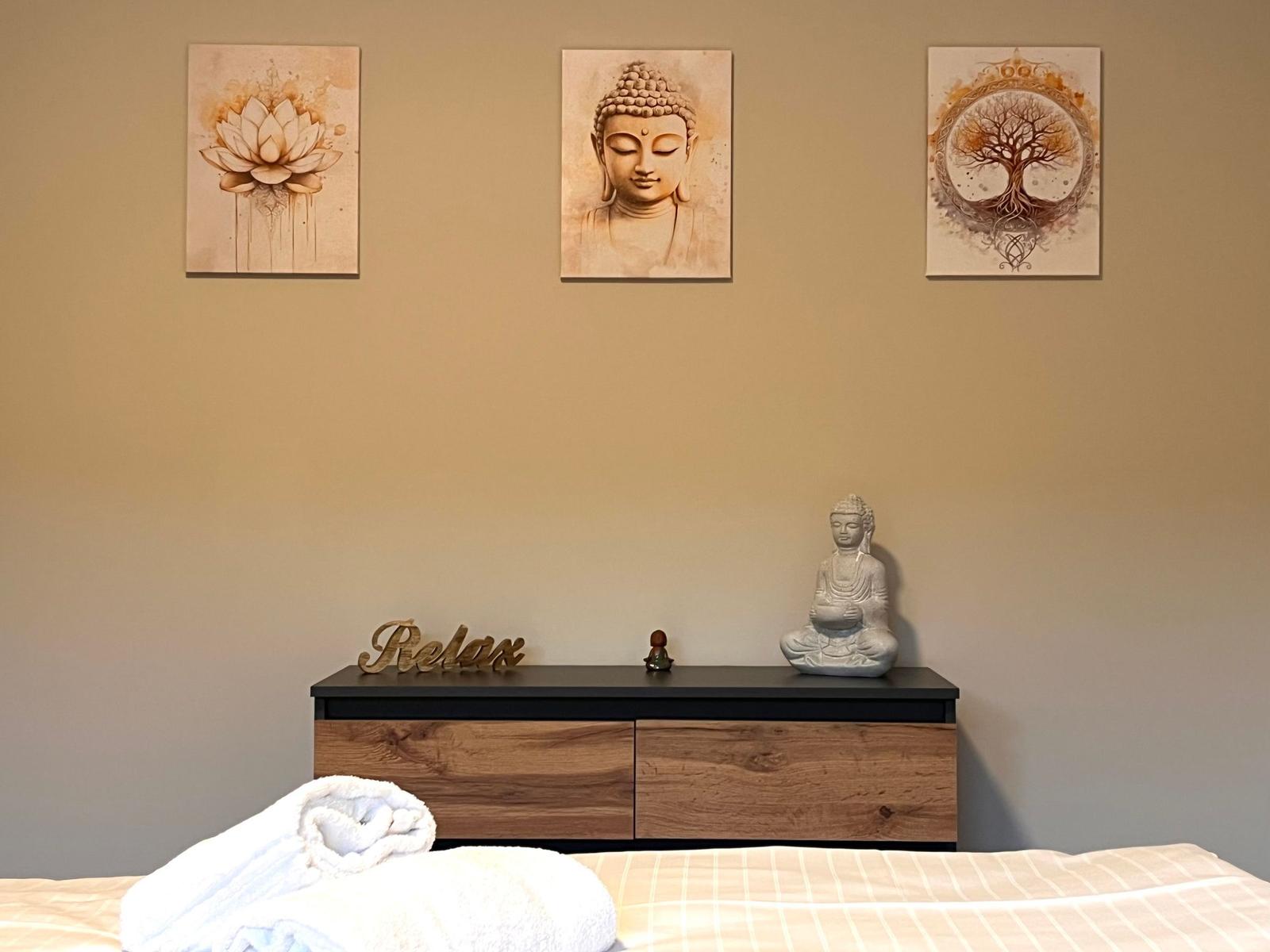 Schlafzimmer mit Buddha-Bildern, Schreibtisch und Bett