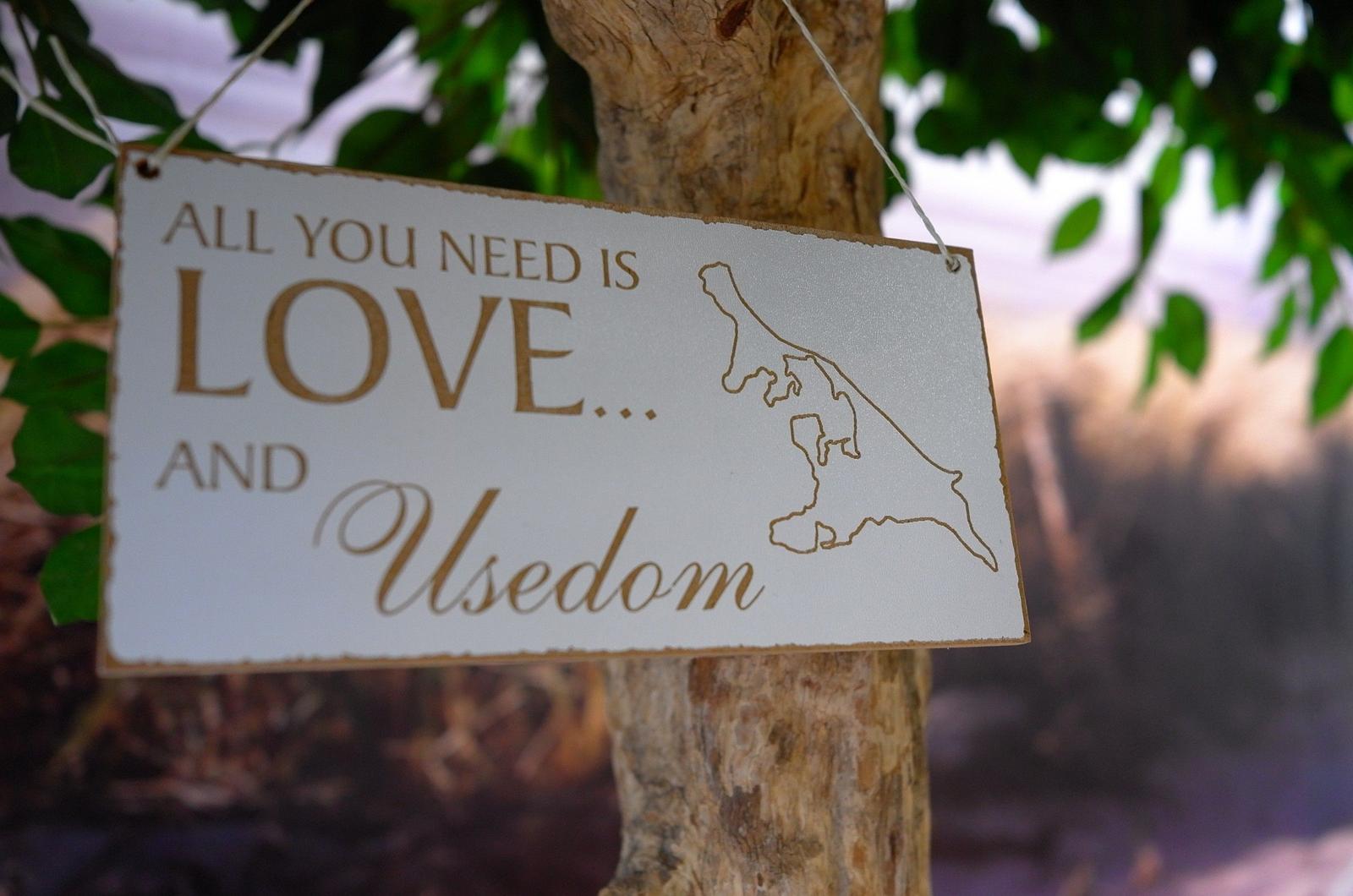 Schild mit Motiv Usedom hängt an einem Baum.