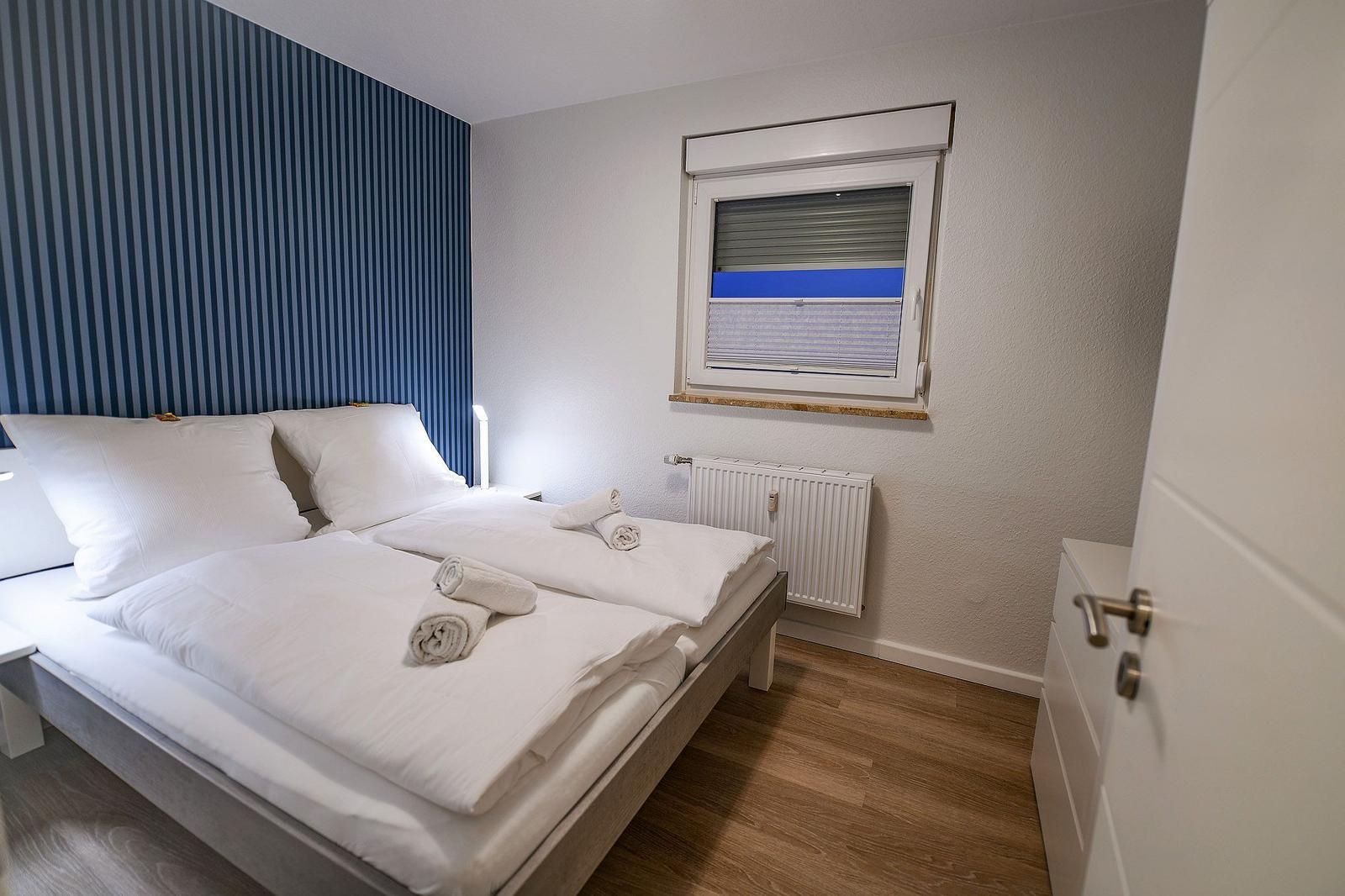 Schlafzimmer mit Bett, Fenster und Heizkörper