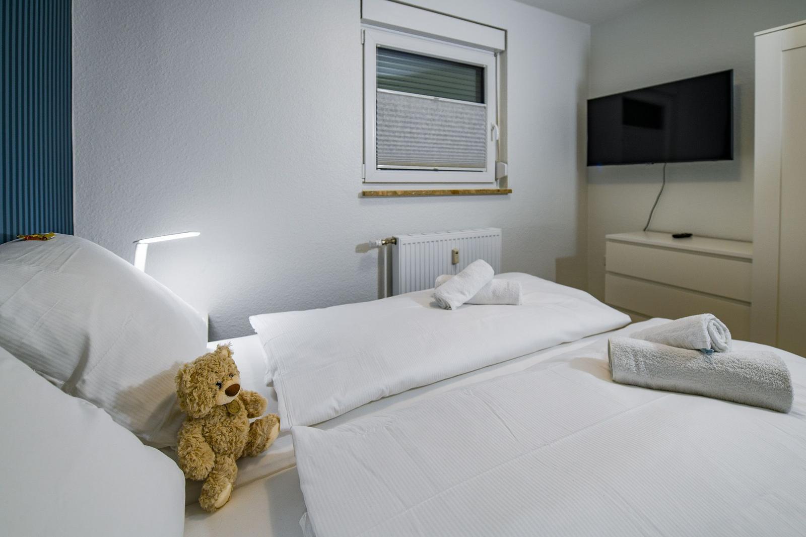 Schlafzimmer mit Bett, Fernseher und Fenster
