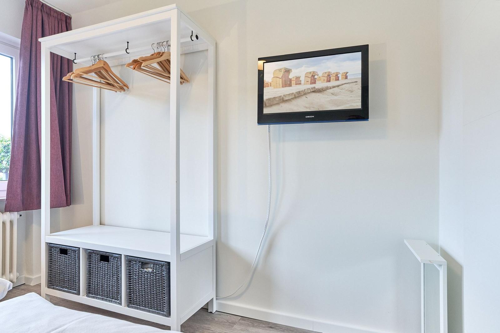 Schlafzimmer mit Kleiderschrank und Wandfernseher