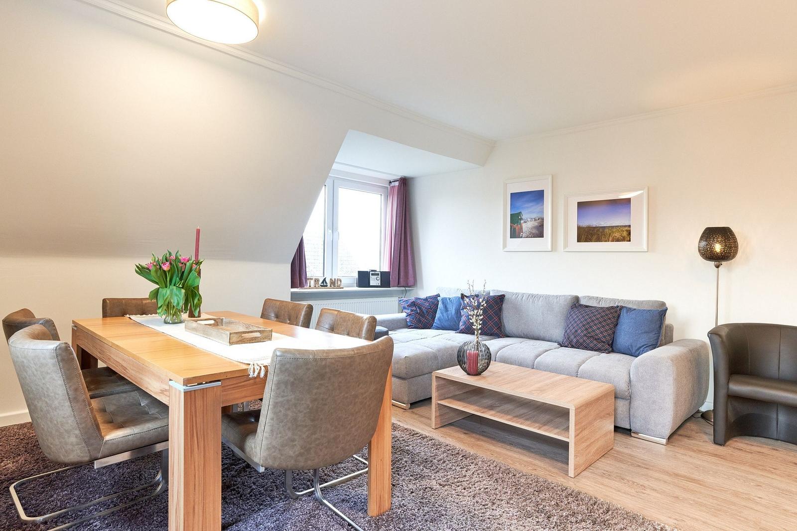 Wohn- und Essbereich mit Sofa, Esstisch und Fenster.