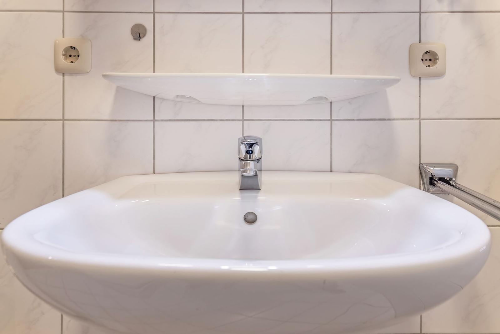 Hochwertiger Waschtisch mit Spiegel und Chromarmatur in moderner Badezimmerausstattung.