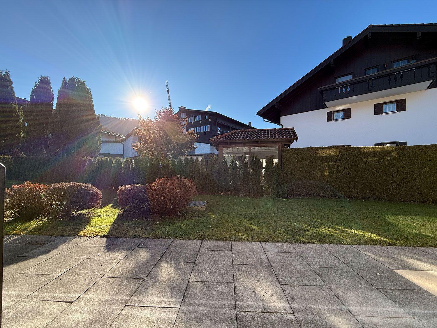 Haus mit Garten, Terrasse und sonnigem Standort unter klarem Himmel.