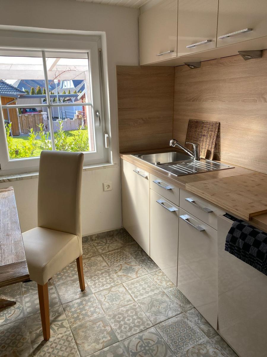 Küche mit Holzoberflächen, Spüle und Blick auf Garten.