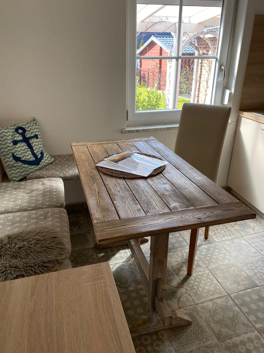 Holztisch mit Stuhl und Fensterblick auf Garten