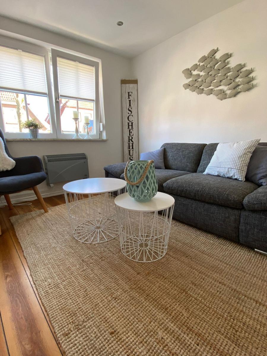 Wohnzimmer mit Sofa, zwei Tischen und Wanddekoration.