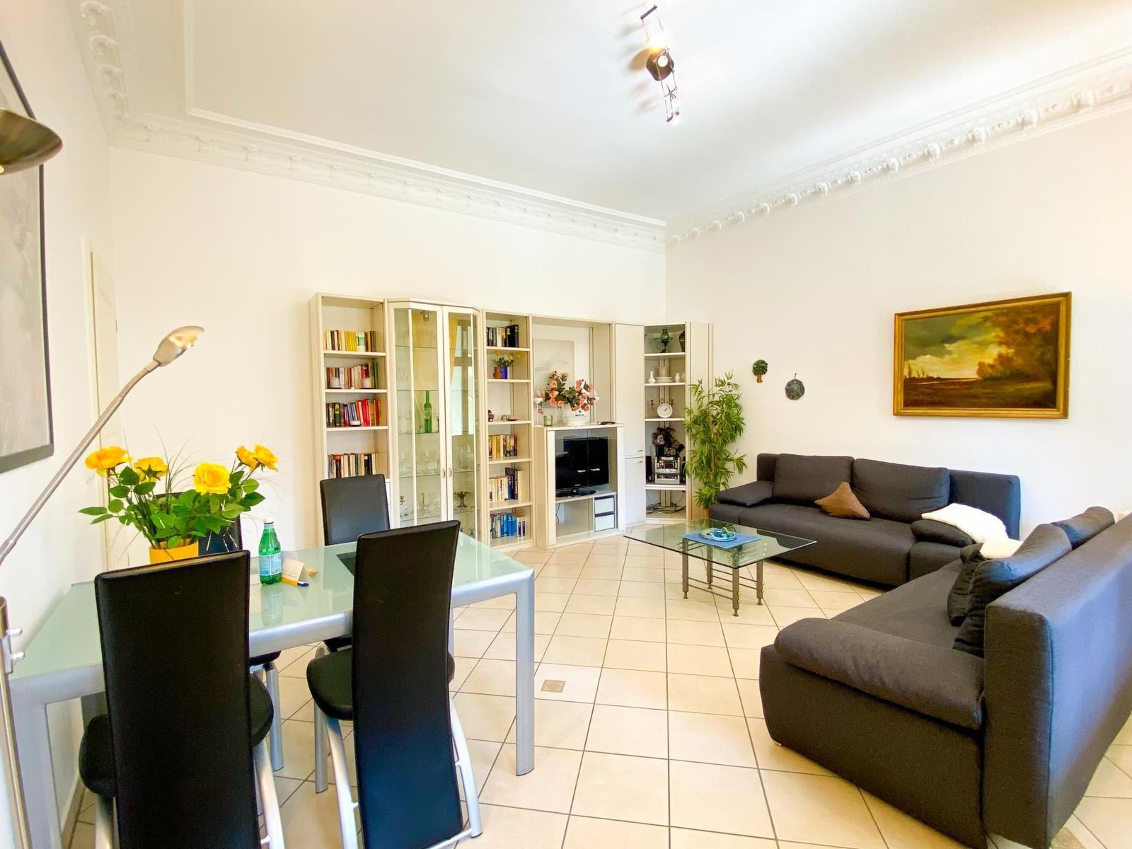 Wohn- und Essbereich mit Sofa, Esstisch und Bücherregalen.