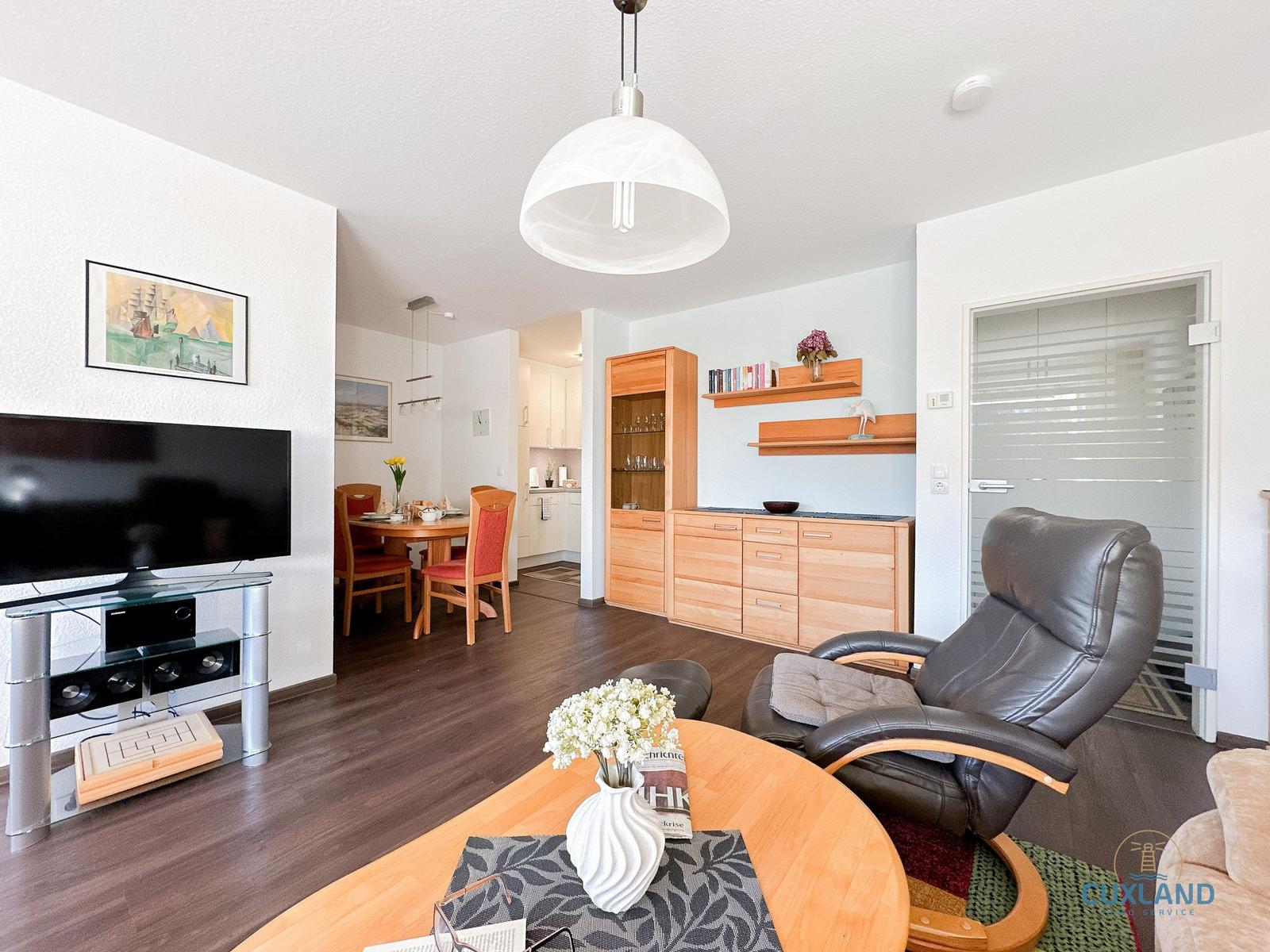 Wohn- und Essbereich mit Fernseher, Esstisch und bequemer Sitzgelegenheit.