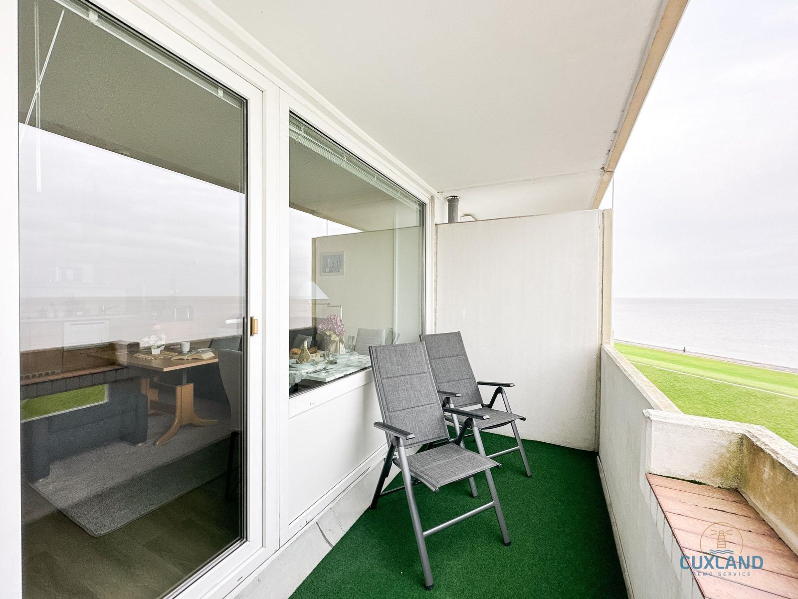Terrasse mit zwei Stühlen und Blick auf den Strand und das Meer.