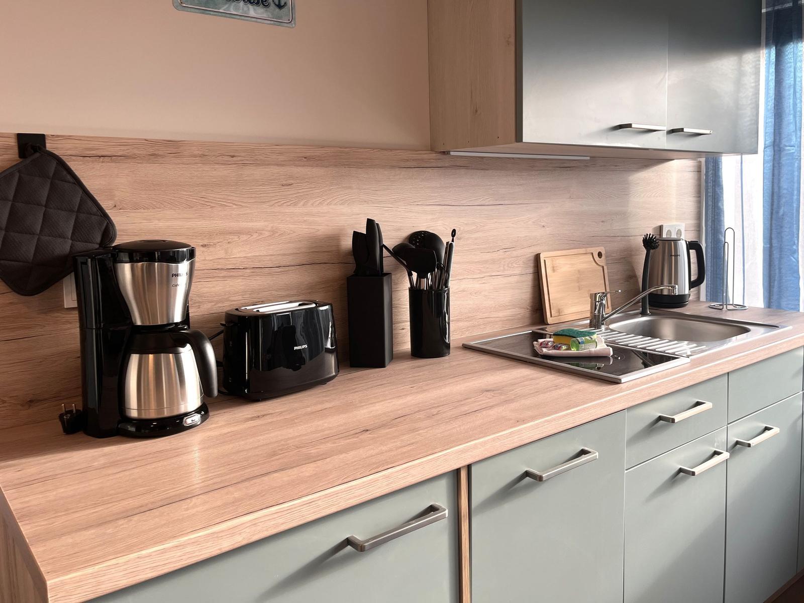 Küche mit Arbeitsplatte, Spüle, Kaffeemaschine und Toaster.