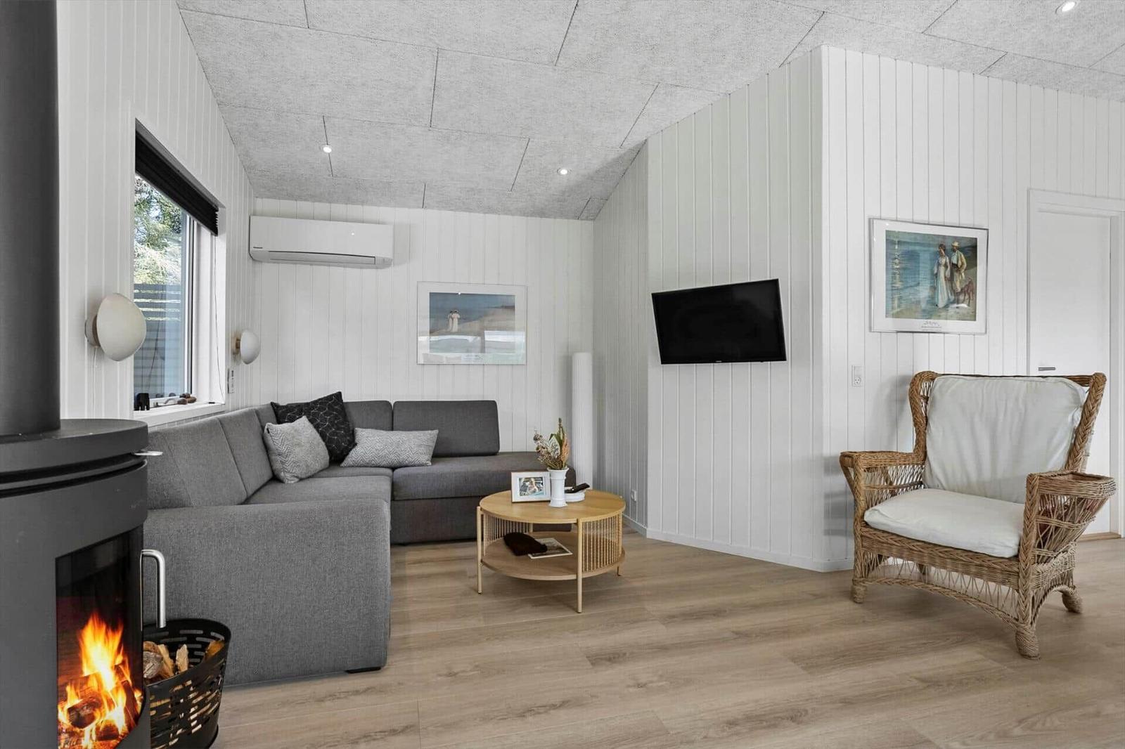 Living room with sofa, fireplace, TV, and chair.