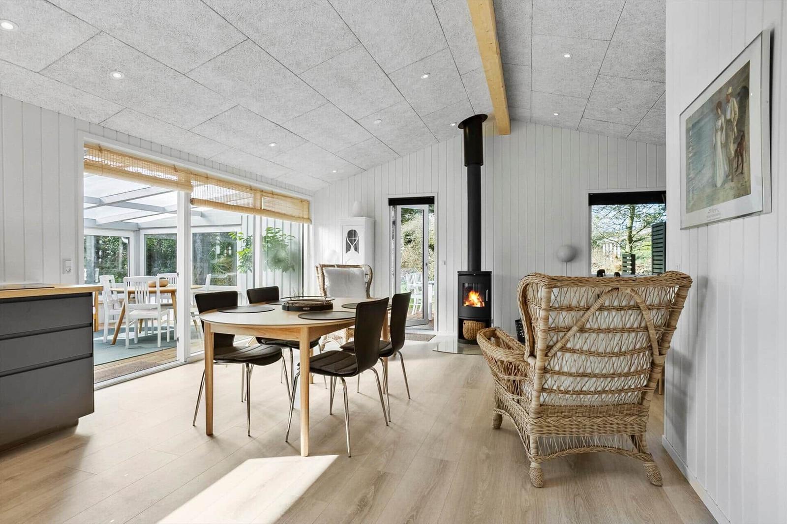 Dining area with table, chairs, and wood stove. Access to terrace and living area.