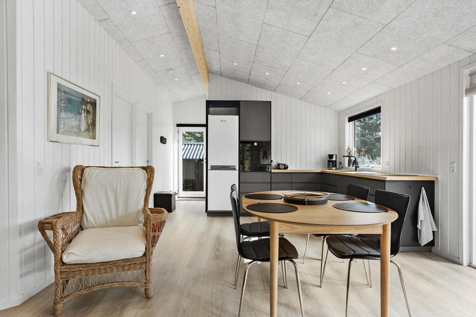 Kitchen with dining area, dining table with chairs and wicker chair
