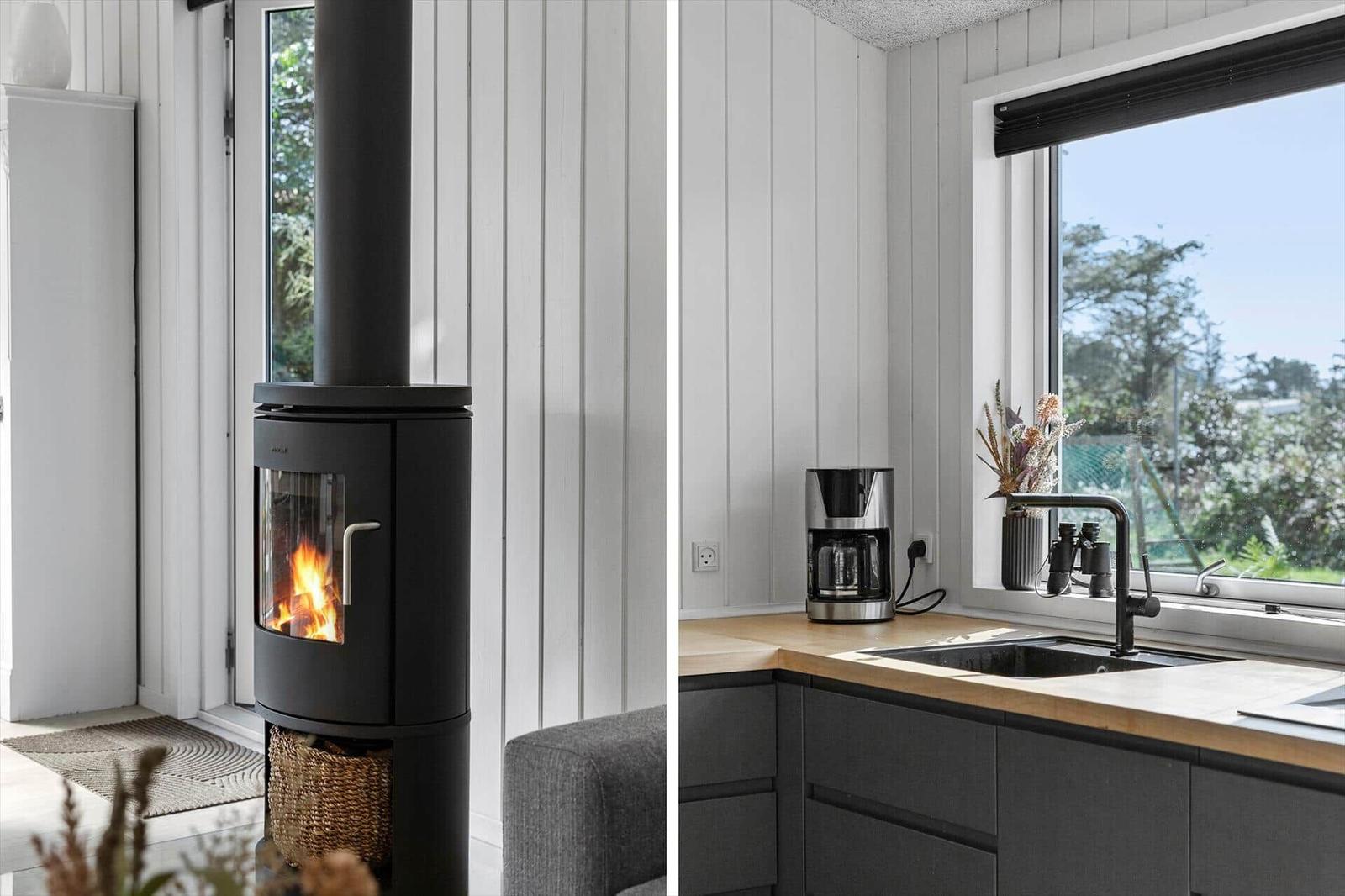 Kitchen with window and sink. Living area with wood-burning stove and seating.