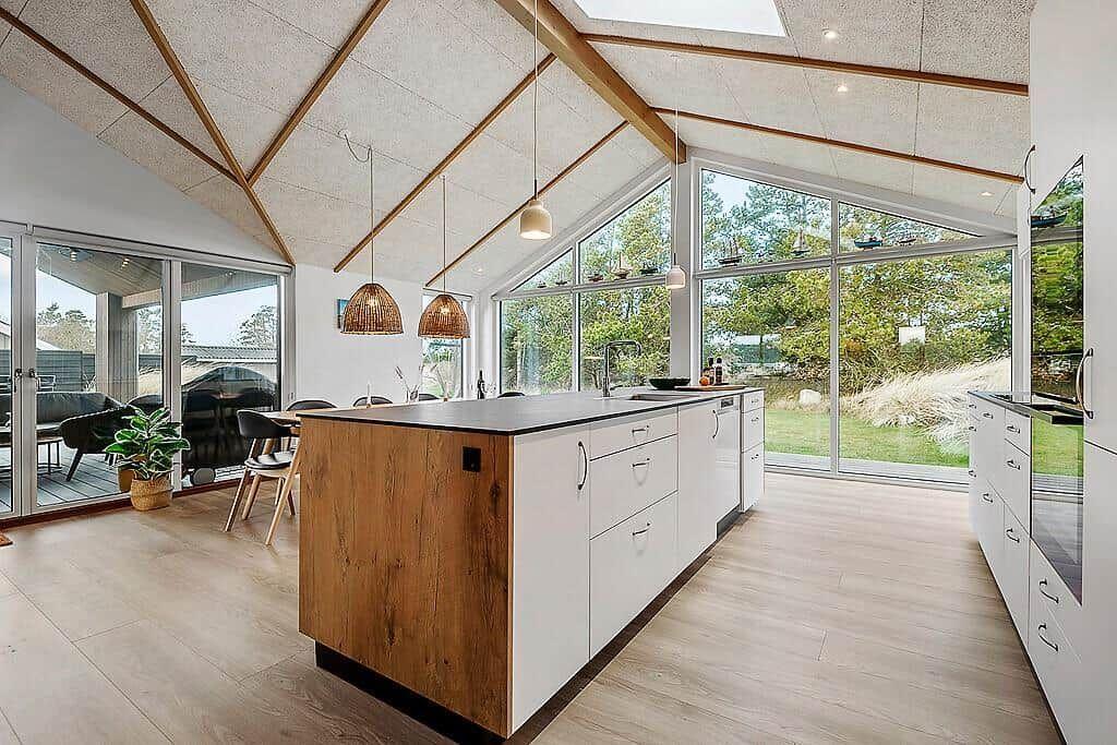 Kitchen with island, wood floor, and large window view of garden