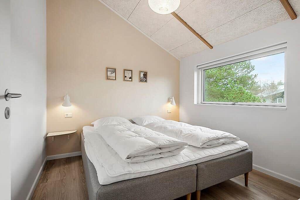 Bedroom with double bed, window, and wall lamps