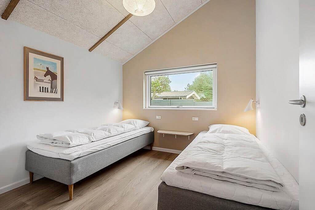 Two single beds, window with view, wall picture, wooden floor, ceiling light